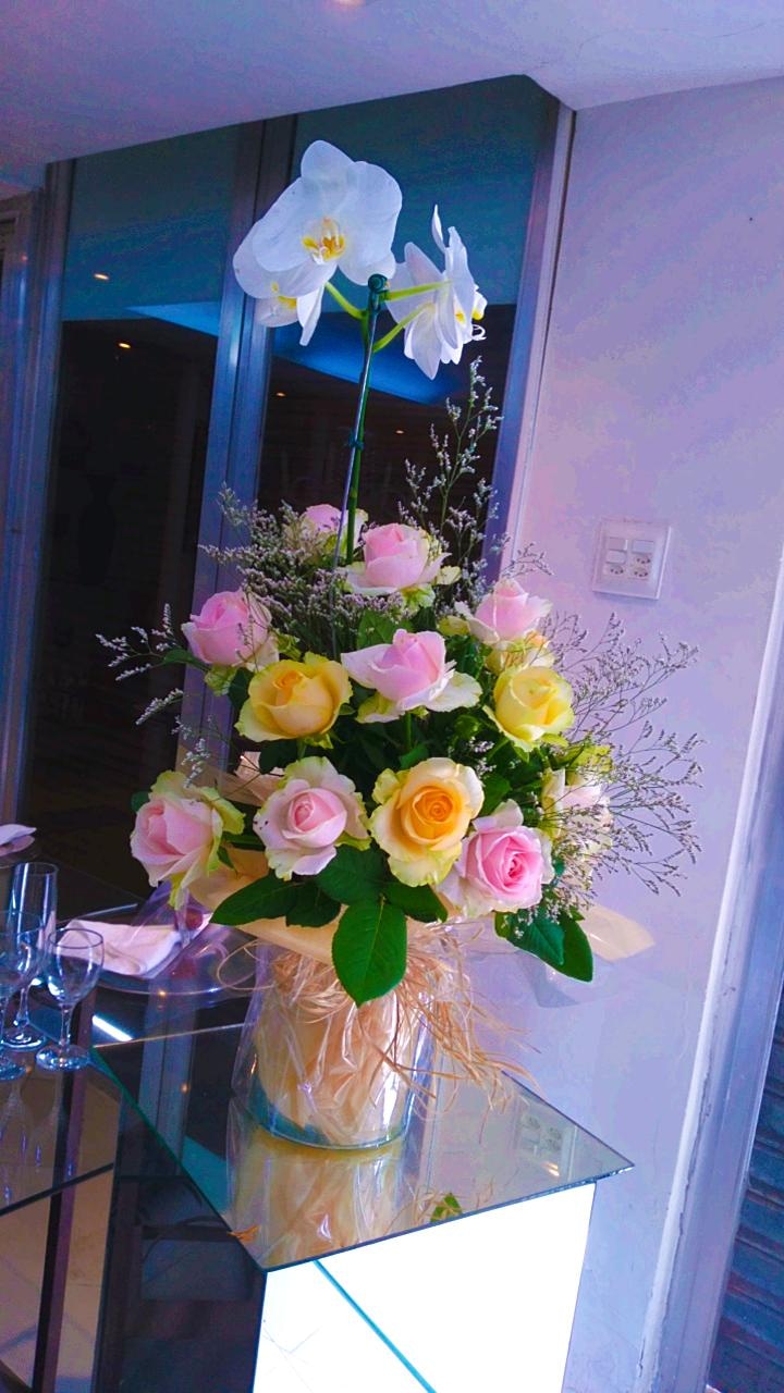 Arranjo de orquídea branca e rosas amarelas e cor de rosa